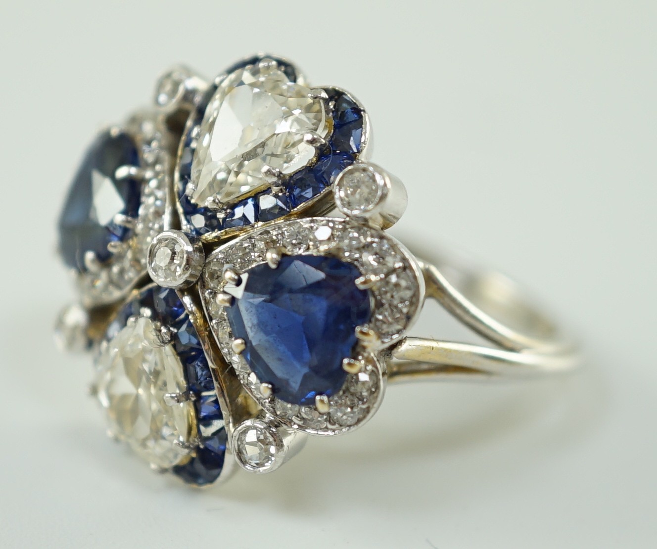 An attractive 18ct white gold, two stone heart shaped diamond and two stone heart shaped sapphire set cluster ring